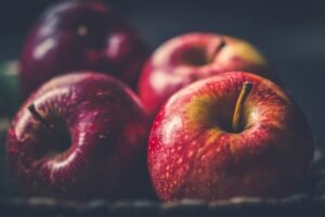 Vibrant red apples glistening with freshness in a close-up view.